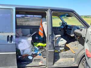Volkswagen Transporter z otwartymi drzwiami bocznymi i bałaganem w środku