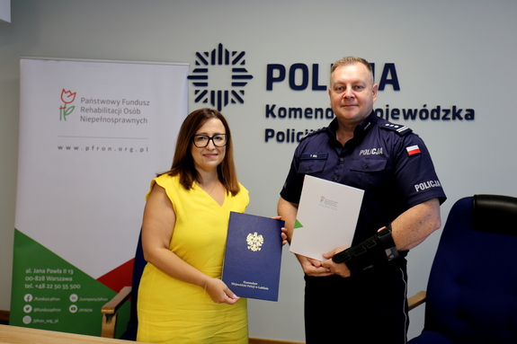 Komendant Wojewódzki Policji w Lublinie- inspektor Tomasz Gil oraz reprezentująca Państwowy Fundusz Rehabilitacji Osób Niepełnosprawnych Dyrektor Oddziału Lubelskiego PEFRON - Pani Monika Wac podczas podpisywania umowy