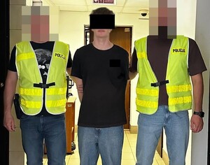policjanci prowadzą zatrzymanego 18latka