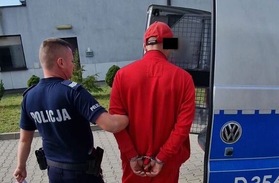 poszukiwany z kajdankami na rękach prowadzony przez policjanta do radiowozu