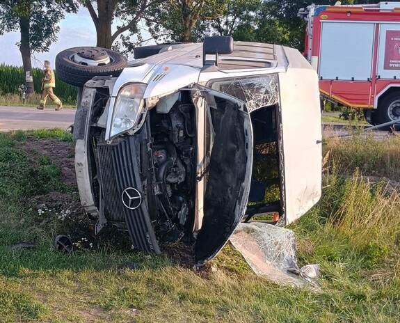 biały Mercedes przewrócony na bok po wypadku