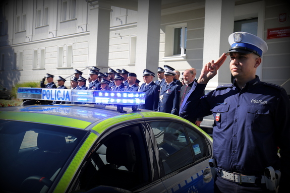 policjant oddaje hołd przed budynkiem Komendy Wojewódzkiej Policji w Lublinie