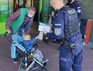 policjanci rozdają maseczki w sklepie