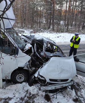 Wypadek busa z poeugeotem. Dwa pojazdy po zderzeniu. Policjant podczas oględzin